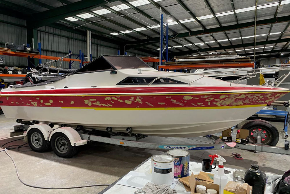 Fibreglass boat with visible repairs prior to wrap